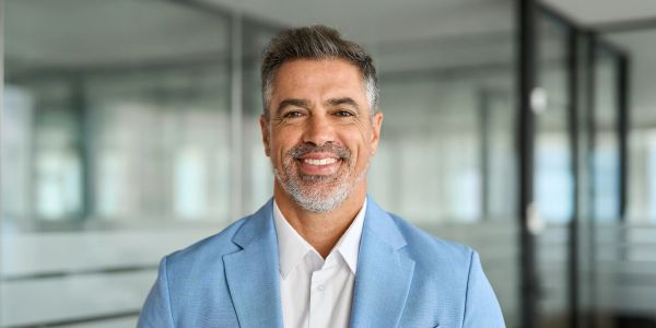 Smiling middle-aged man in a light blue blazer.