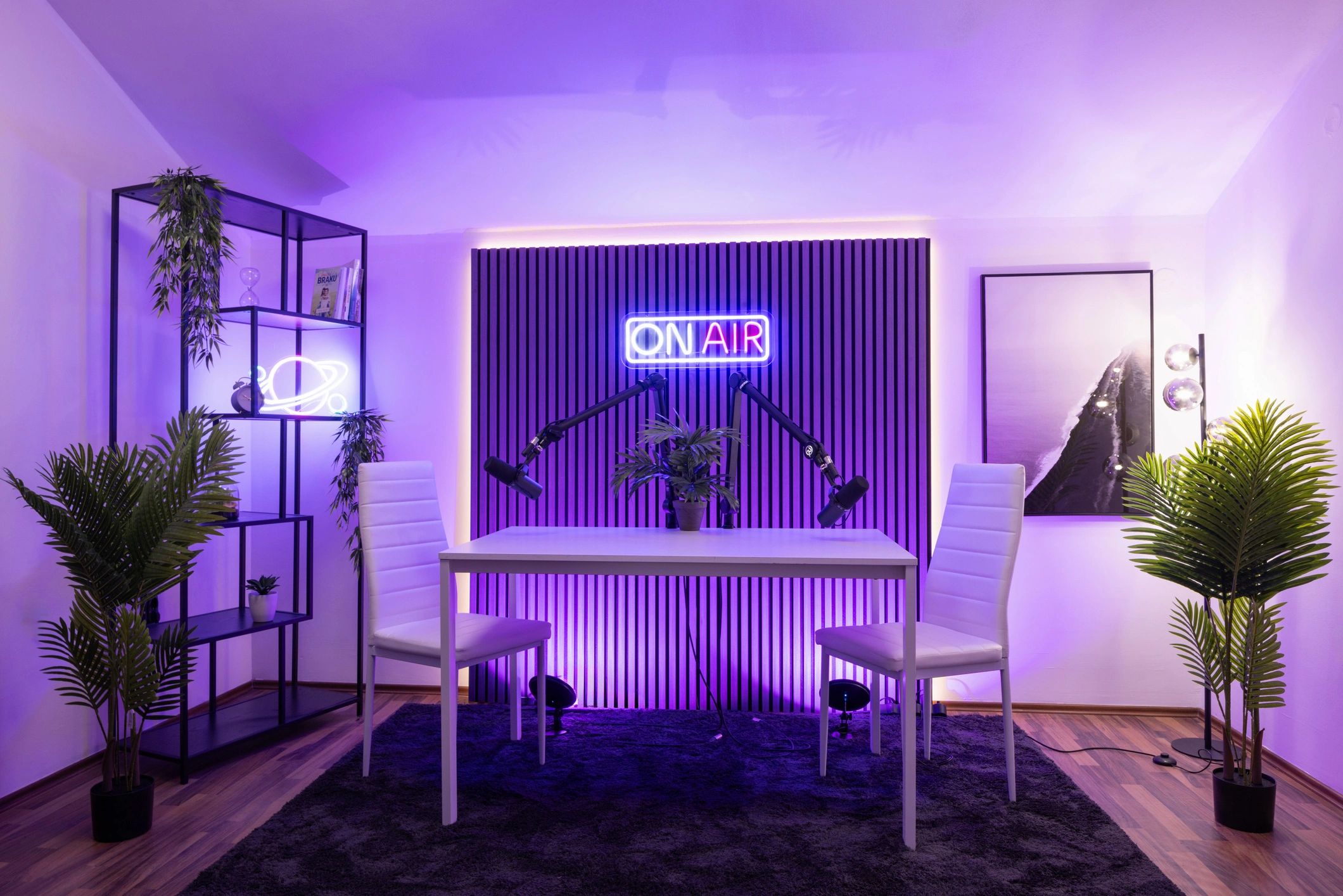Modern podcasting studio with purple lighting and two microphones.