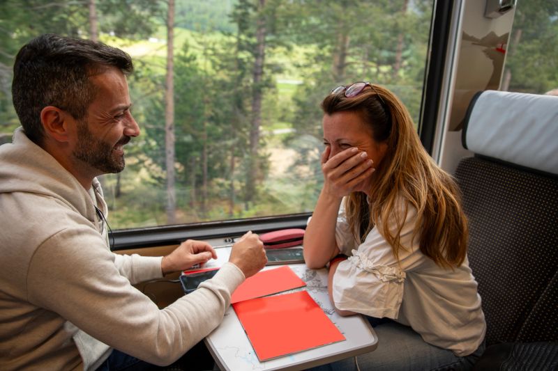 Friends having fun and laugh on a  train journey in European Alps