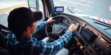 Man driving a truck, focused on the road.