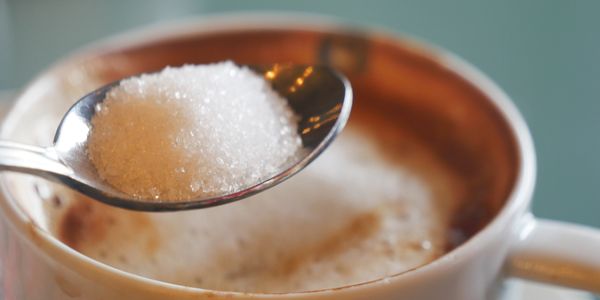 Spoonful of sugar over a cup of coffee.