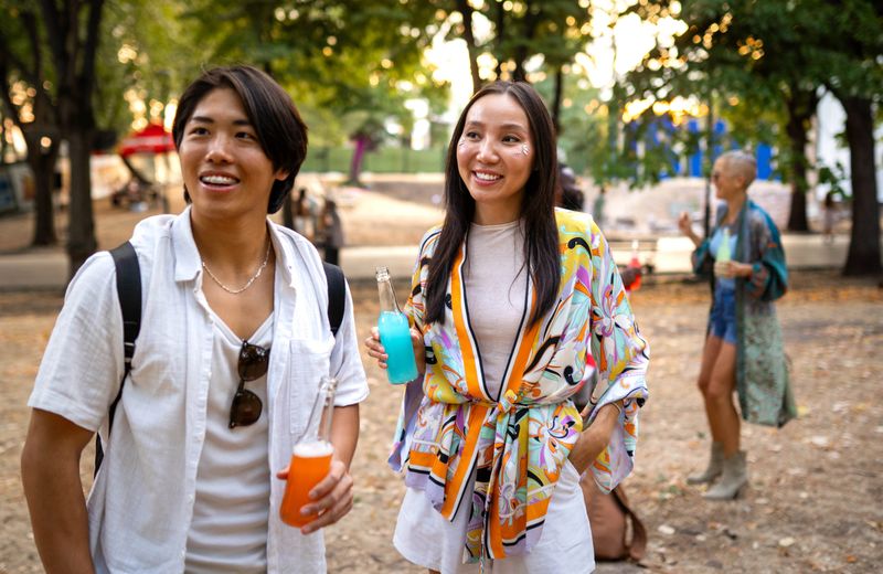 Excited young adults celebrating together at a lively outdoor music festival under the sunset