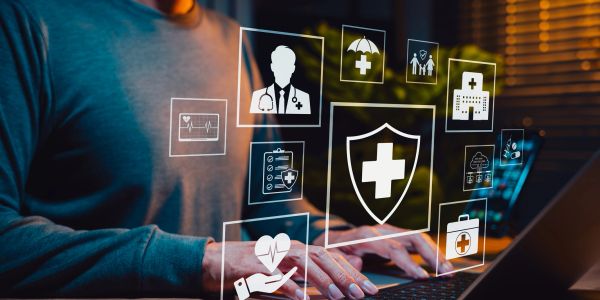 Person using laptop with healthcare icons floating.