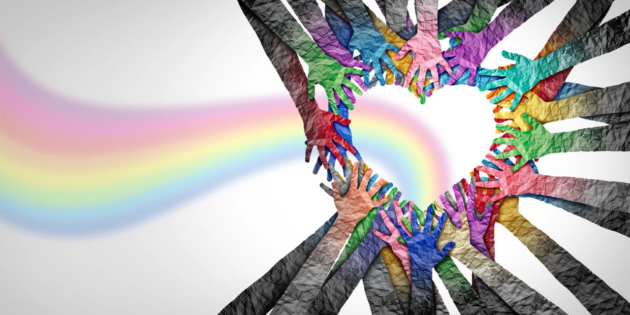 Colorful hands forming a heart with a rainbow inside.