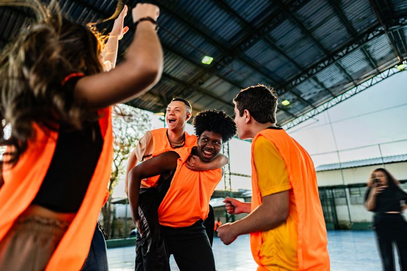 Students celebrating on a school sport court- including a student boy with down syndrome