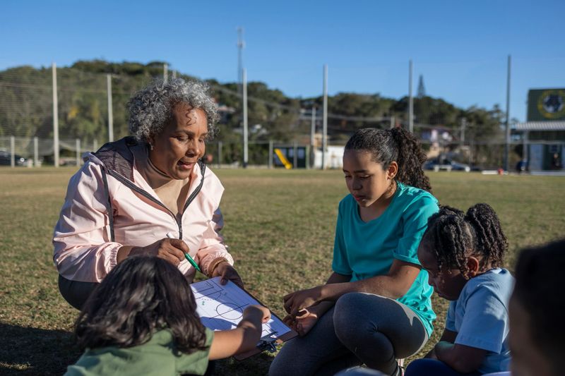 Experienced soccer coach with children during training on a soccer field