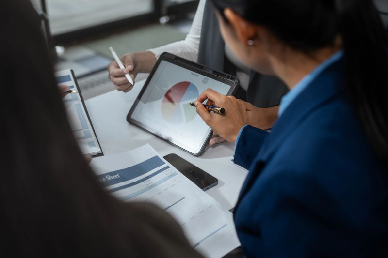 Entrepreneurs, marketers, managers, and financial analysts gather around the table to analyze data, present results, plan strategies, discuss efficiencies,grow their businesses through collaboration