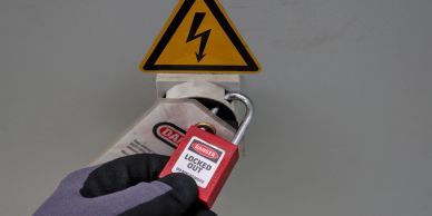 Person placing a lockout tag on a power switch.