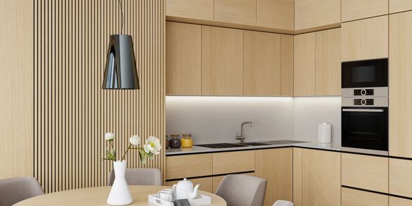 Modern kitchen with light wood cabinets and a round dining table.