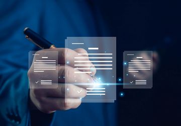Person digitally signing a document using a stylus and laptop.
