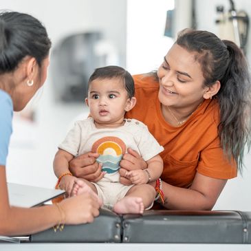 Mother holding baby during a doctor visit.