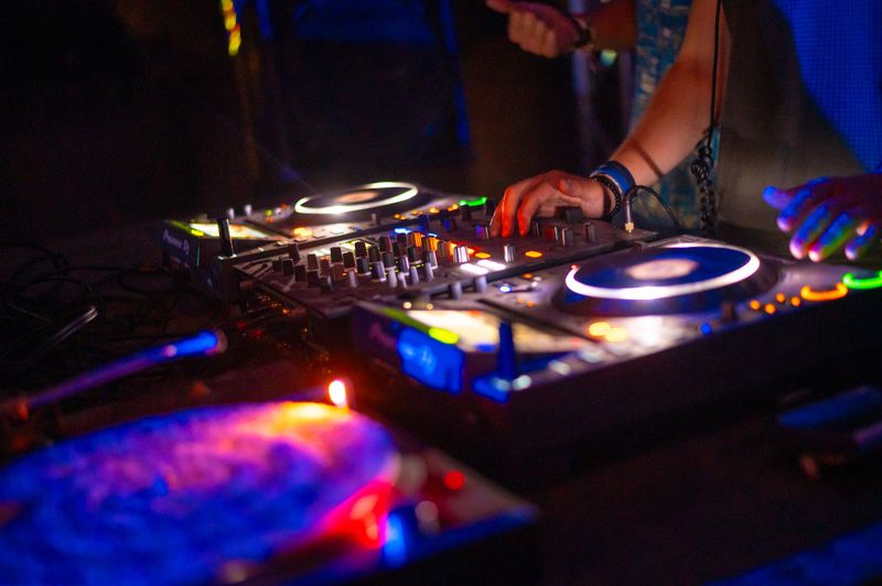 Two young dj's playing techno music on the concert stage in summer.