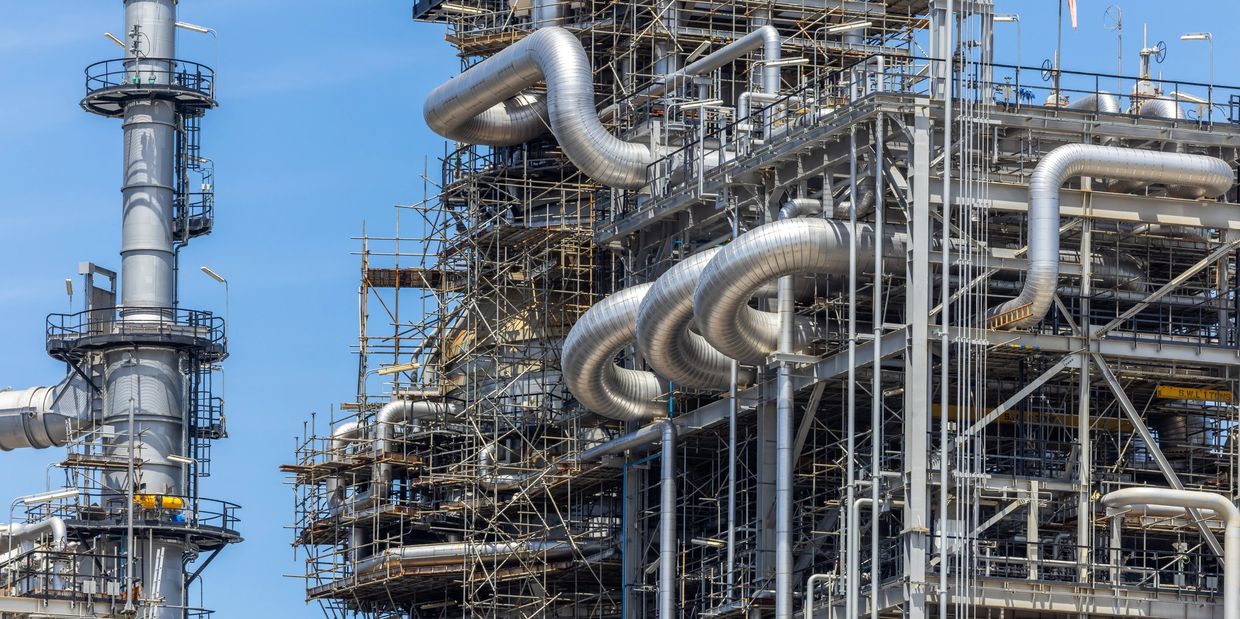 Large industrial refinery with complex pipes and scaffolding.