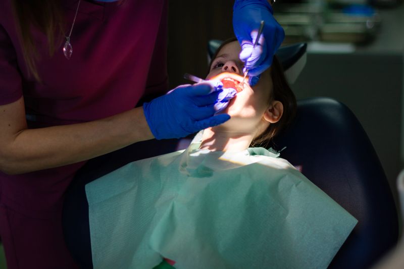 Child having teeth examined by a dentist during a routine check-up