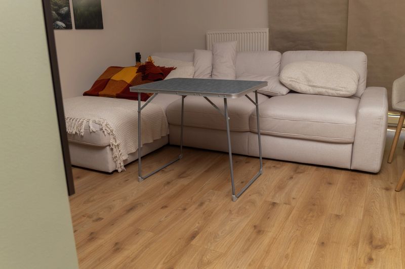 Living room with sofa, cushions, and folding table in cozy setting