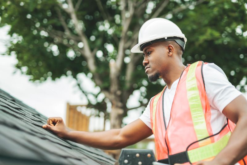 A black man with hard hat to house inspector