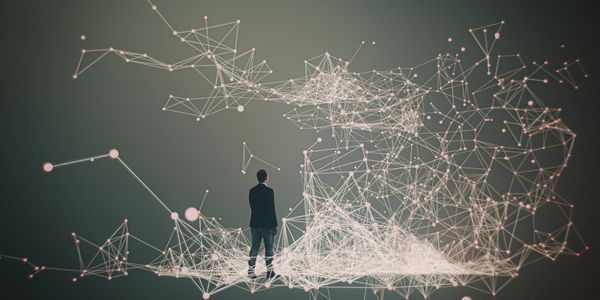 A person stands amidst a complex network of glowing interconnected nodes and lines.