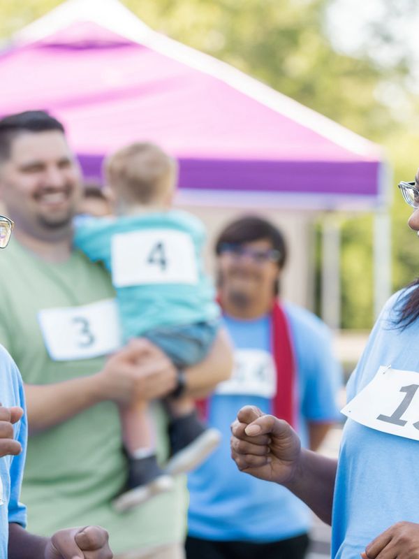 Group of people with numbered bibs at an outdoor event.