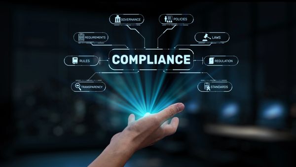 Hand presenting digital compliance concepts.