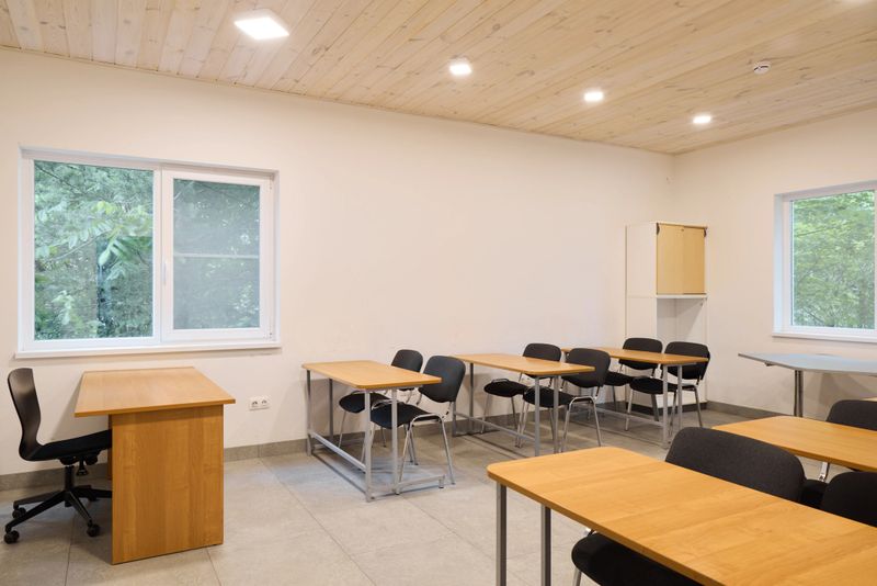 This spacious and modern classroom showcases abundant natural light, stylish desks, and minimalistic decor