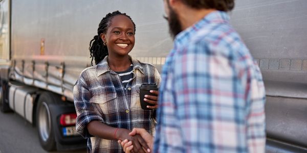 Person smiling, shaking the hand of an Instructor.