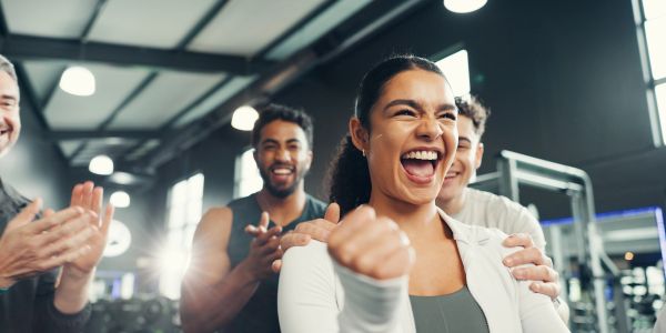 Group celebrating a woman's achievement with applause and smiles.