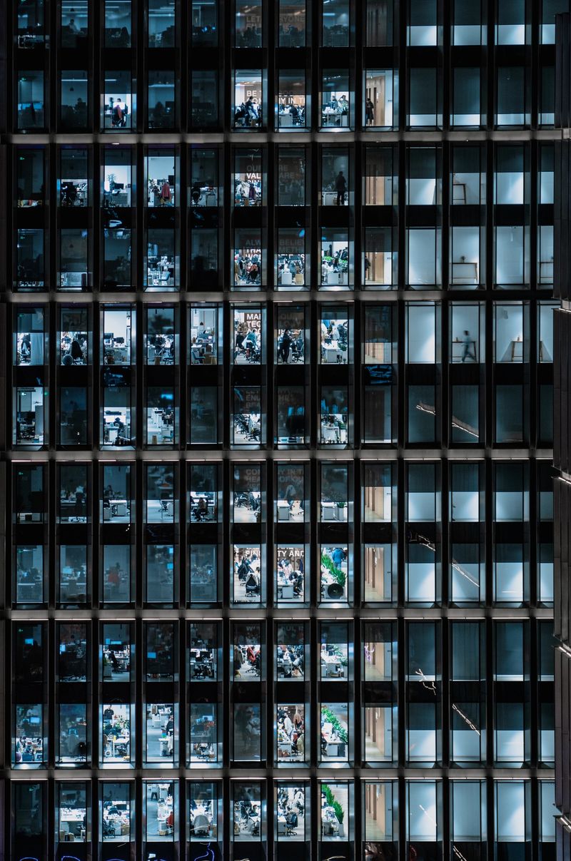 Office Building Windows, Business People Working in Office Business Building at Night.