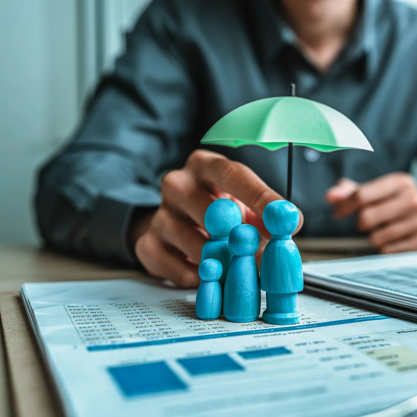 A family of figurines standing under an umbrella resembles counselling for families in Echuca. 