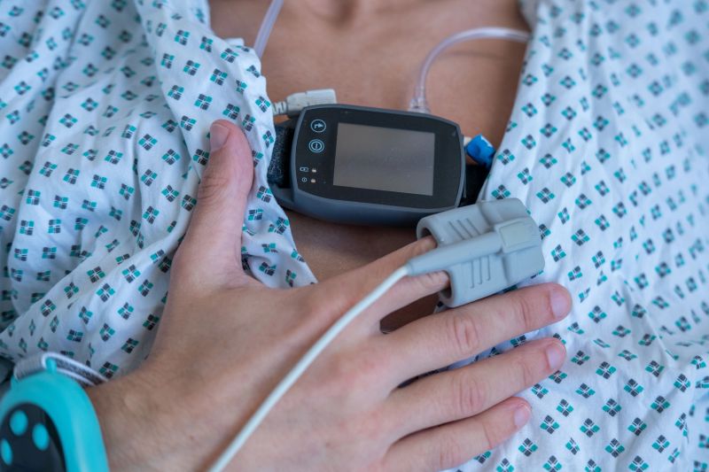Young person, man with sleep apnea monitoring device and fingertip pulse oximeter, male patient health tracker, adolescent sleep study equipment, youth breathing disorder research concept