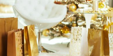 Gold and white gift bags near a white chair.