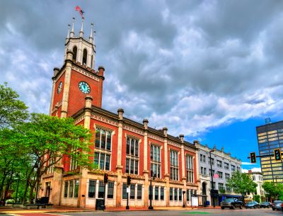 Historic building with clock tower under a cloudy sky.