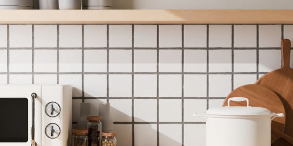 Minimalist kitchen countertop with white appliances and wooden accents.
