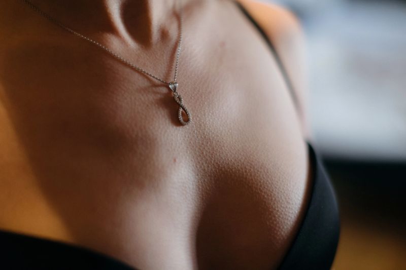 This is a detailed closeup view of a beautiful necklace elegantly resting on a persons chest, showcasing its intricate jewelry details