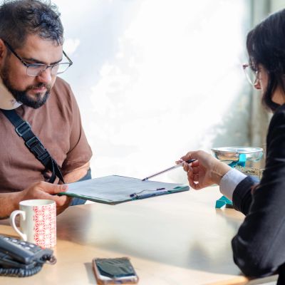 Two people engaged in a discussion over documents at a table.