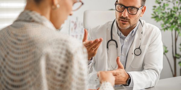 Doctor consulting a female patient in a medical office.