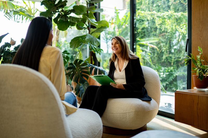 Senior psychotherapist woman talking to teenage patient girl