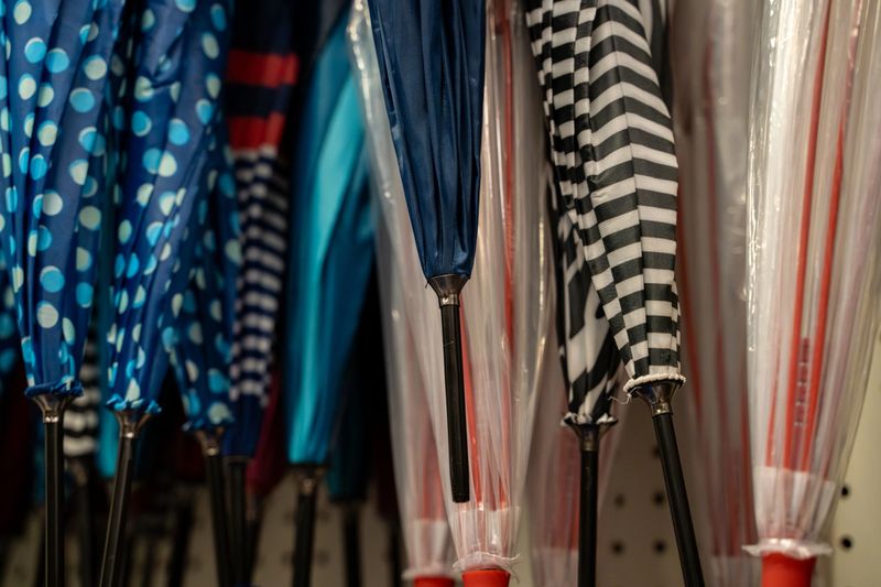 Close up of colorful umbrellas with different patterns hanging in store.