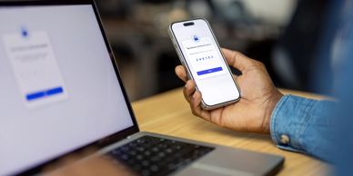 Person logging into an account using phone and laptop.