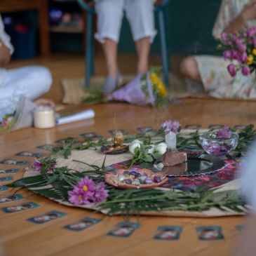 Circle of people around a decorated altar with flowers and candles.