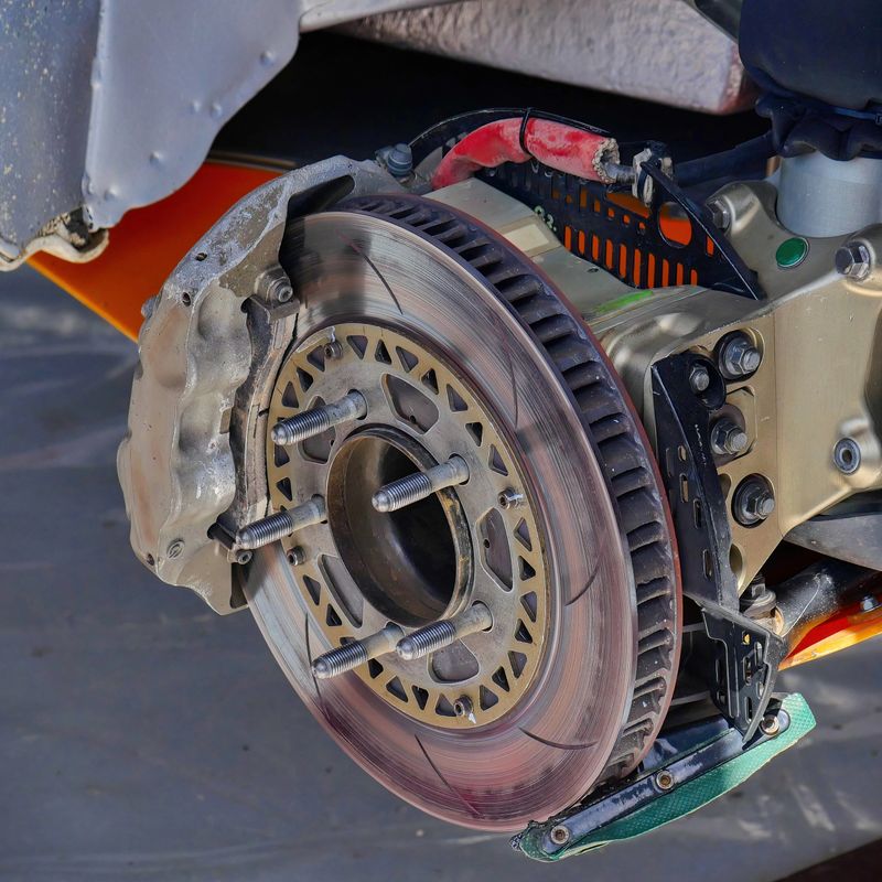 Close-up of a car brake disc and caliper without a wheel. Detailed view of automotive braking system components.
