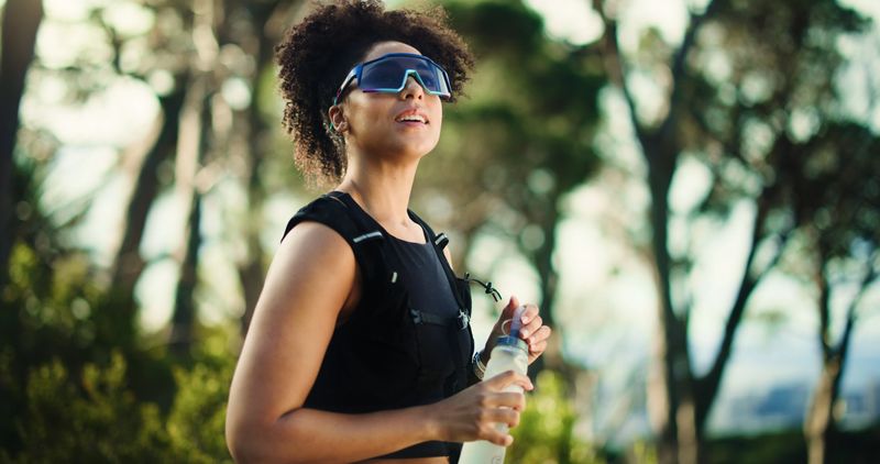 Break, thinking and water with woman in forest for fitness, hydration or training as runner. Exercise, hiking and planning with athlete person outdoor in nature for challenge, performance or workout