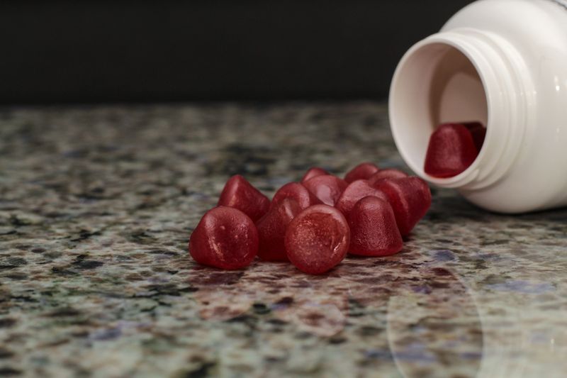 Gummy Supplements Spilling from Container onto Kitchen Counter