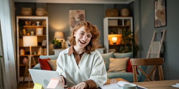 Happy woman working on a laptop at home.