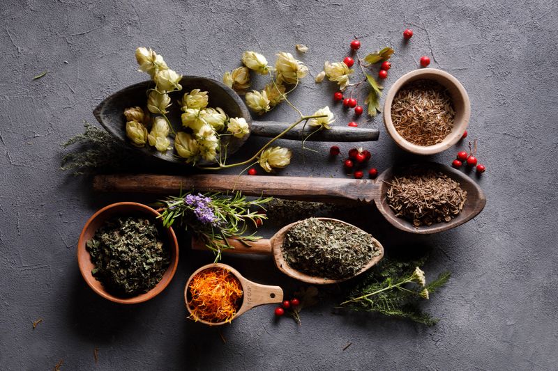 Herbs in old wooden spoons and bowls
