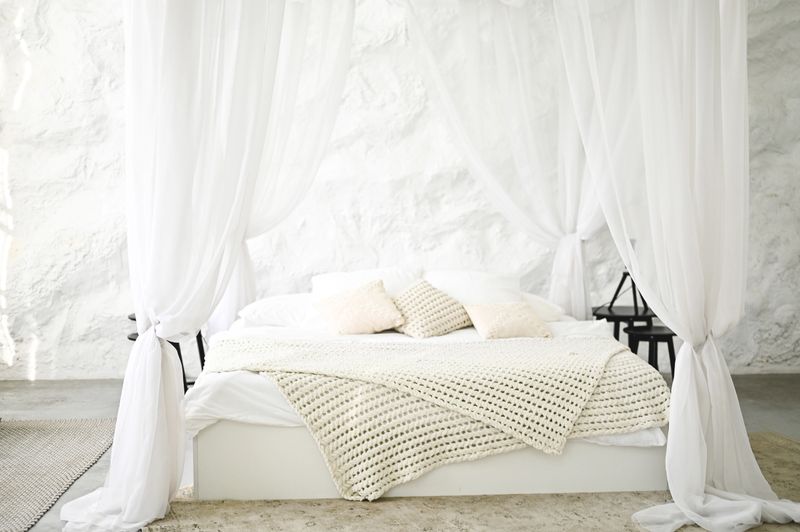 Romantic bedroom featuring a rustic white textured wall and cozy bedding