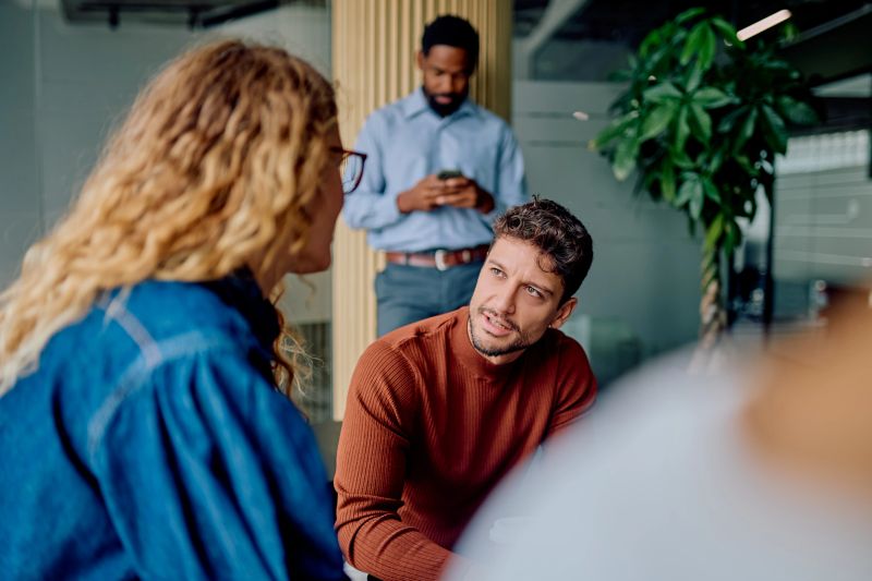 Engaging professionals communicating and brainstorming during a casual meeting in a contemporary workspace, focused on teamwork and innovation