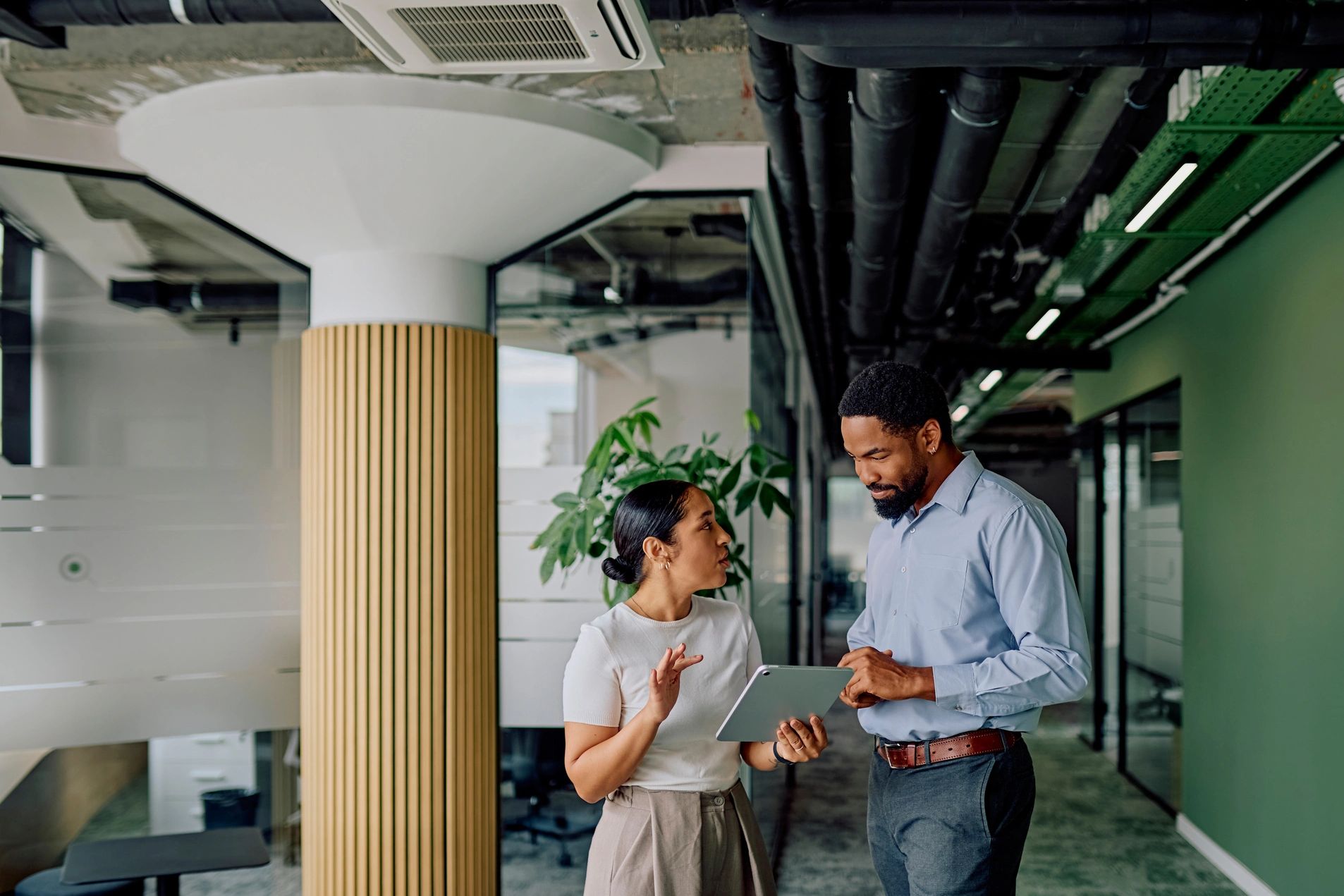 Two professionals engaged in a friendly conversation in a bright office space.
