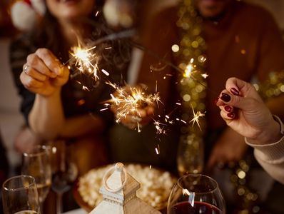 People holding sparklers at a festive gathering.