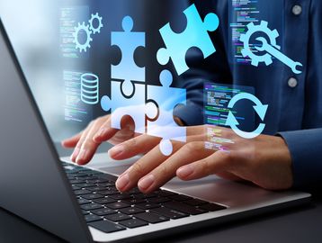 Person typing on a laptop with digital puzzle and gear icons representing software development.