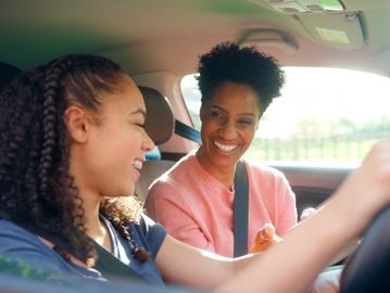 Two women smiling inside a car.
